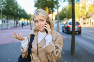 Donna al telefono in attesa, simbolo delle chiamate non gestite senza Call Queueing aziendale.