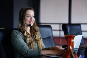 Donna al lavoro con computer portatile, simbolo di flessibilità del centralino virtuale
